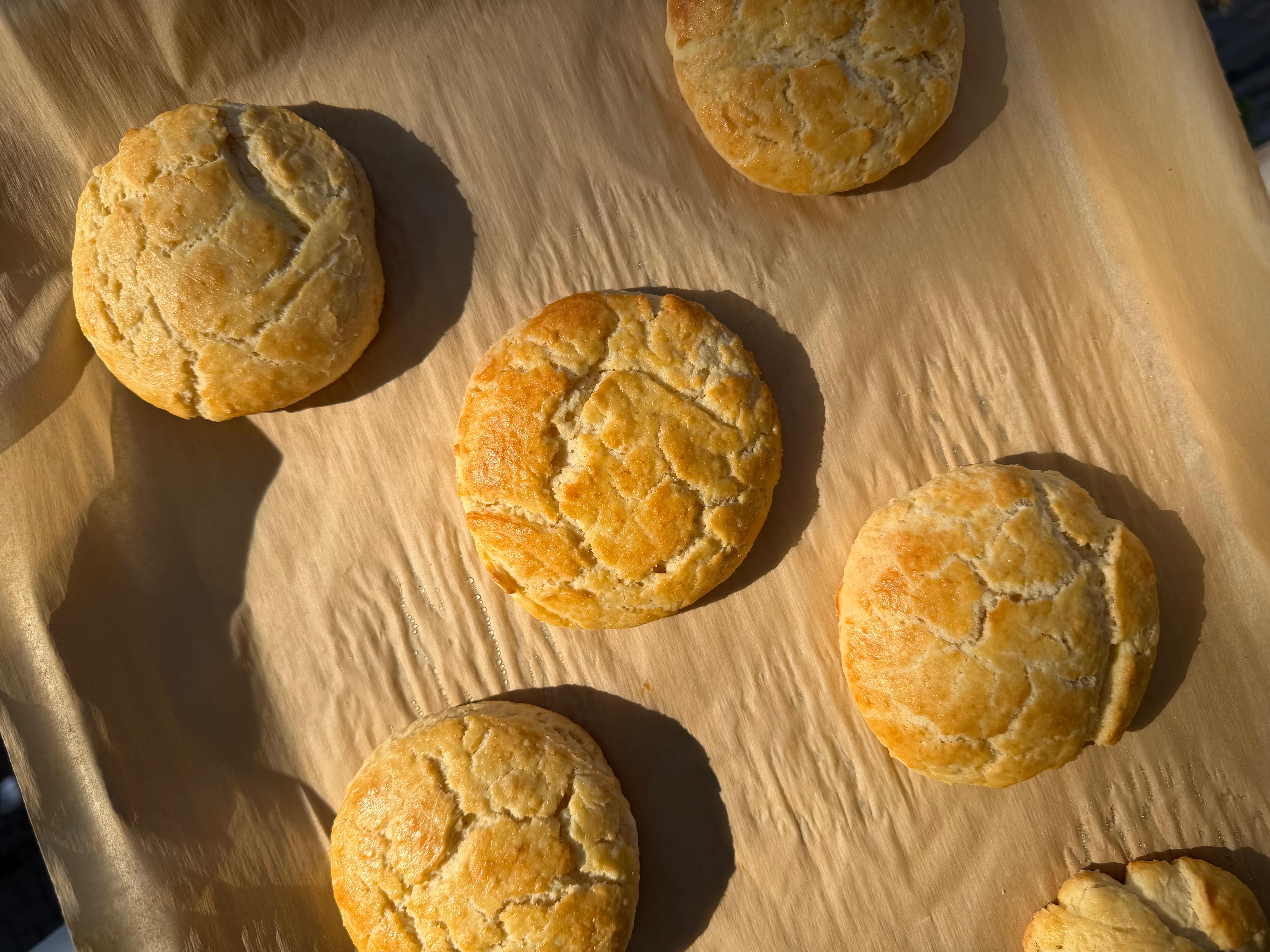 Buttermilk biscuits on a baking tray, with a golden brown crust.